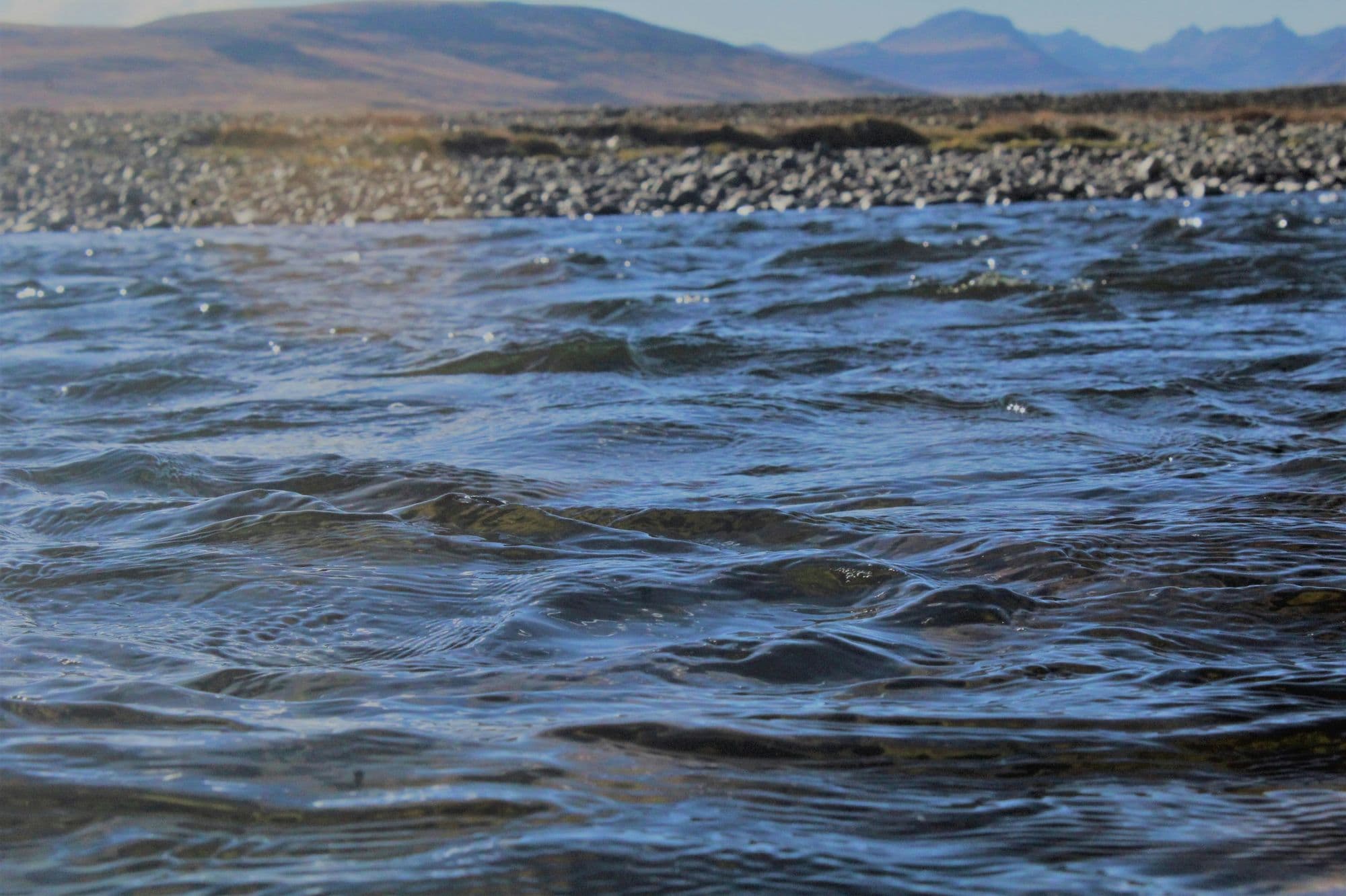 Snow-dusted hills and a mountain stream on the Deosai plateau, Astore side