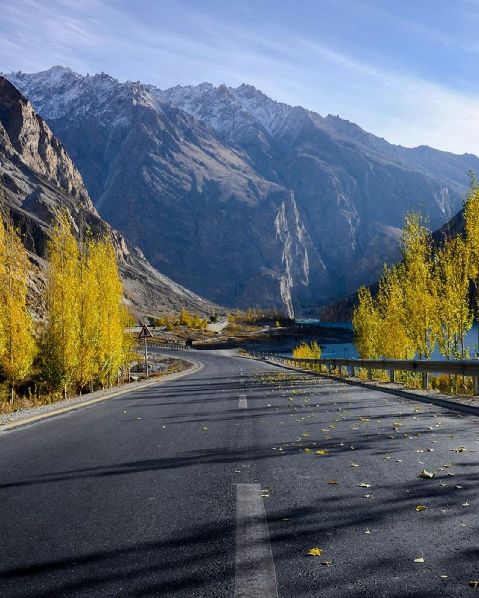The Karakoram Highway running between poplar trees and dry brown mountainsides