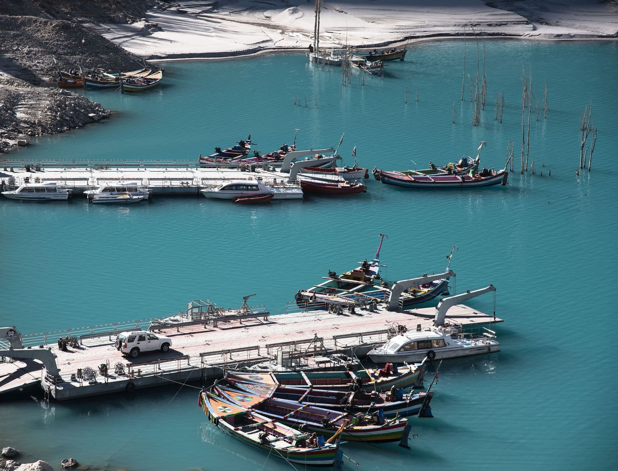 Aerial view of colourful boats moored at the jetty on turquoise Attabad Lake, Hunza