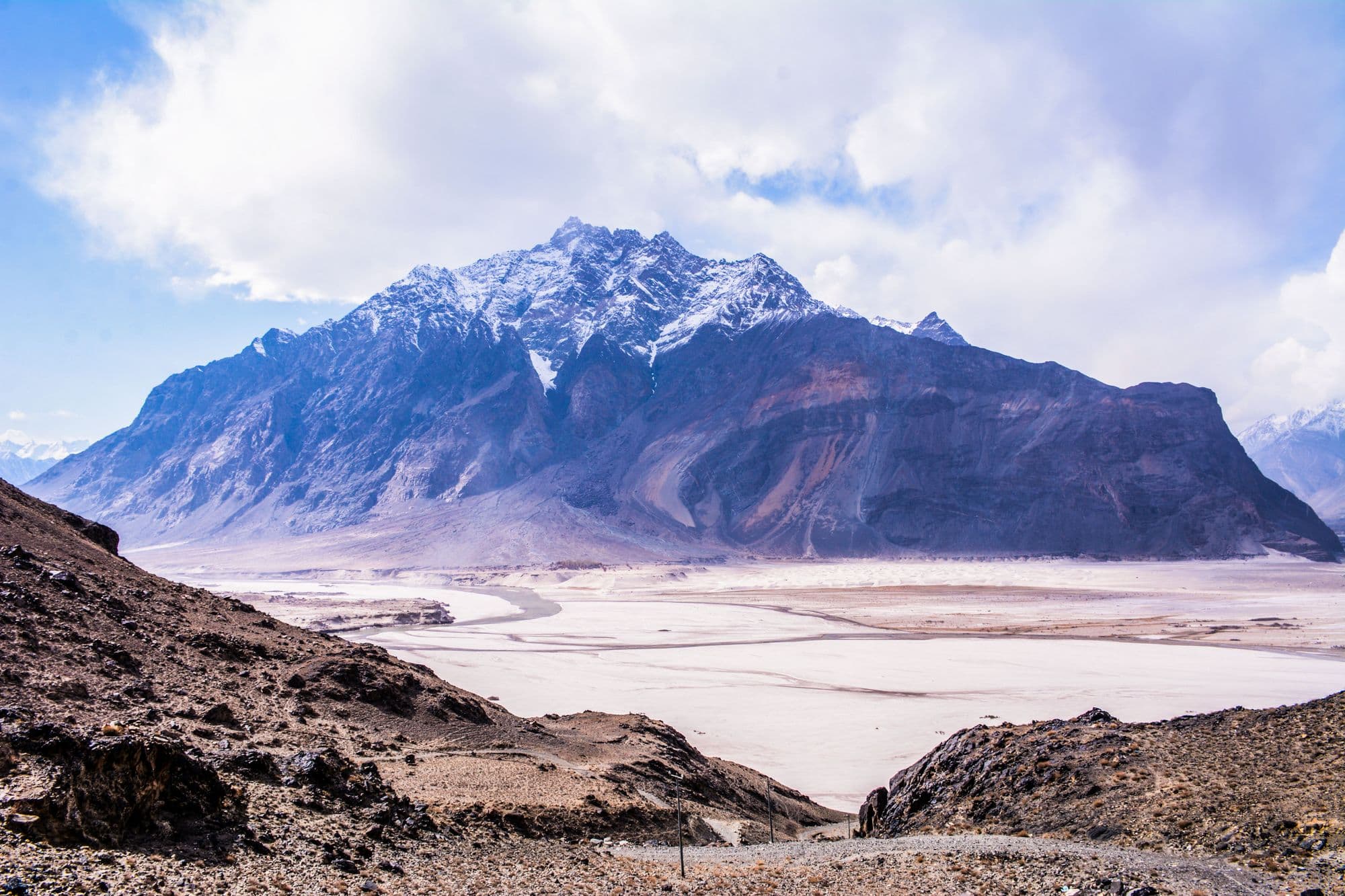 Snow-dusted Karakoram mountains rising above the sand dunes of the Skardu cold desert, Gilgit-Baltistan
