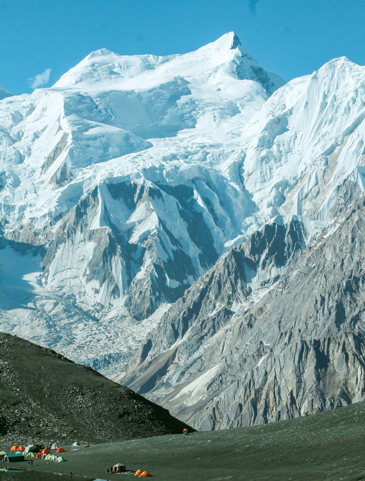 Camp beside a glacier below snow-capped peaks in the Hoper valley, Nagar, near the end of the Hispar route
